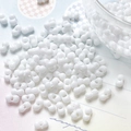 Macro shot of white peanut-shaped double-hole beads for DIY jewelry making and crafts - White