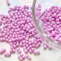 Macro shot of light purple hourglass shaped acrylic beads for DIY jewelry making - Purple