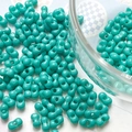 Close-up of vibrant turquoise double-hole peanut beads for DIY jewelry making - Bamboo Green