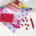 Detailed view of 4mm frosted red glass beads for DIY jewelry making in a plastic storage box - Red