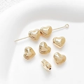 Detailed macro of 14k gold heart-shaped spacer beads with textured edges and side holes - Universal Specification / 18K Gold