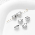 Macro shot of 14k gold plated heart spacer beads on a needle for DIY jewelry making - Universal Specification / White Gold