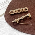 Dettaglio di spille a balia placcate in oro con design a catena e cavo ritorto - Catena Torta (Oro 18K) / Oro 18K