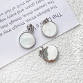 Detalle de colgantes redondos de plata bañada en oro con nácar blanco y reverso de metal - Estilo 9