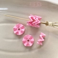 Macrodetail van roze golfvormige acrylkralen voor DIY-sieraden en handgemaakte armbanden - Roze