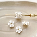 Macro-opname van gegolfde acrylkralen voor DIY-sieraden op een keramische schaal - 13# Wit