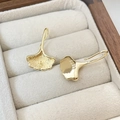 Macro view of 14k gold-plated ginkgo leaf ear hooks with detailed veins and S925 stamp - Gold