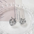 Dettaglio di orecchini a fiocco e fiori cavi in argento su vassoio di vetro - Argento Liscio
