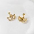 Detailed view of gold-plated mask earrings with micro-pave cubic zirconia inlay - Gold