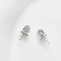 Macro detail of silver bell-shaped earring pin pendants for DIY jewelry crafting - White Gold Style