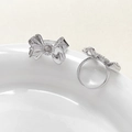 Detail of silver bow ring base with zircon accents and pearl setting on ceramic tray - White Gold Style / Silver