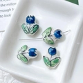 Macro detail of hand-painted blue tulip ceramic beads for DIY jewelry and crafts - Blue