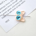 Macro shot of cartoon monster cat charm with striking blue eyes and silver pin detail - 4# Pink Double Eye Cat (D4171)