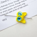 Macro shot of a yellow cartoon cat bead showing the perforation hole with a metal needle - 10# Yellow Double Eye Cat (D4171)