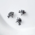Dettaglio macro di perni per gioielli placcati color canna di fucile con zirconi lucidi - Design sacchetto di soldi con fiocco Gunmetal (Prezzo per pezzo 3#)