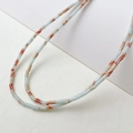 Macro detail of 2x4mm tube beads featuring natural blue and orange marble textures - Shoushan Stone