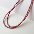Macro detail of natural rose quartz tube beads in elegant pink and red gradient hues - Red Aventurine