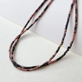 Close-up of 2x4mm natural rhodonite tube beads with marble texture for jewelry making - Rhodonite