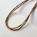 Detailaufnahme von 2x4mm Naturstein-Röhrenperlen mit marmorierten Mustern und Texturen - Jaspis