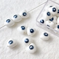 Macro shot of white heart ceramic beads with blue evil eye pattern for DIY jewelry - Heart Evil Eye / Pearlescent White