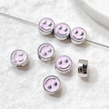 Macro view of silver alloy smiley face beads with pink enamel for DIY jewelry making - Silver