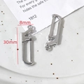 Détail macro de breloques scie argentées pour bijoux DIY avec mesure précise de 30mm - Scie à Main (10#)