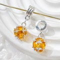 Macro shot of silver-tone charms with sparkling orange cubic zirconia in a cage setting - Style 4 (Amber Rhinestone)