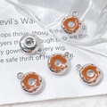 Close-up of orange enamel donut charms for DIY jewelry making on white textured paper - Silver Orange Donut (5# Silver Single Price)