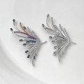 Detailed macro view of gold-plated wing charms with multicolor zircon stones and honeycomb back - White Gold Pair