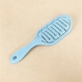 Macro detail of a light blue hollow vented hairbrush with massage bead tips and wide teeth - Light Blue