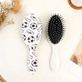 Detail view of two soccer printed oval hair brushes with soft massage bristles and white base - White Football Shoe Sketch Style (C)