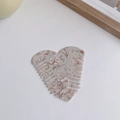 Macro shot of heart-shaped acetate hair comb with cream and brown marble texture - Milk Coffee