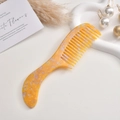 Makro-Detail des grobzinkigen Marmor-Acetat-Haarkamms für Locken-Styling und Pflege - Orange