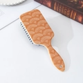 Dettaglio spazzola per capelli gialla con motivo a conchiglia su uno sfondo lifestyle curato - Trama Dorata