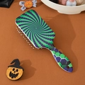 Detail of ergonomic air cushion hairbrush with green and purple geometric spiral patterns - Swirl
