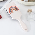 White paddle hairbrush featuring a vintage orange rainbow design and black massage bristles - White Vintage Rainbow Pattern