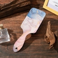 Hairbrush with marble texture back and anti-static massage bristles on wood desk - Blue Pink