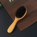 Wooden paddle hairbrush with boar bristles and nylon pins on dark wood background - Small Round Style (GS-MS02)