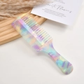 Macro detail of iridescent acetate comb with dual-tooth design on a rustic wooden tray - Fantasy Blue