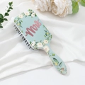 Close-up of air cushion hairbrush with blue floral pattern and pink Mrs text - Customizable Pattern / Rose Gold White Flower