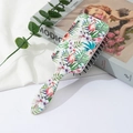 Detail van tropische flamingo-print op een witte luchtkussen haarborstel met zwarte borstels - Flamingo Tropische Jungle Stijl