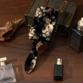 Detail of vintage floral hair brush on wooden surface with elegant perfume bottles - Black With White Flowers