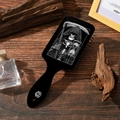 Detail eines gotischen Totenkopfmusters auf einer schwarzen Haarbürste mit Holz Hintergrund - Sensenmann