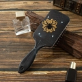 Detail of a black hairbrush featuring a spider web print and embroidered spider patch - Gold Spider Web Pattern