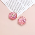 Close-up of pink hexagonal resin guitar charms with gold frames for DIY jewelry making - Pink