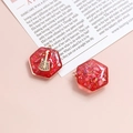 Macro view of a red hexagonal resin charm with gold guitar inlay for DIY jewelry - Red
