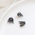 Macrodetail van drie zwart metalen konijnenkop-kralenkapjes met geborstelde textuur - Gun Black (3#)