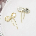 Detailed view of a golden bow pendant with iridescent resin inlay and pearl tassel - Pearl Bow Tassel (20# Gold Tone)