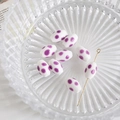 Macro view of white ceramic oval beads with purple polka dots and a gold metal pin - White with Purple Polka Dots (8#)