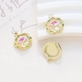 Detalle de colgantes de órbita con centro rosa iridiscente y pequeñas piedras de circón - Estilo Planeta Mágico Rosa Oro